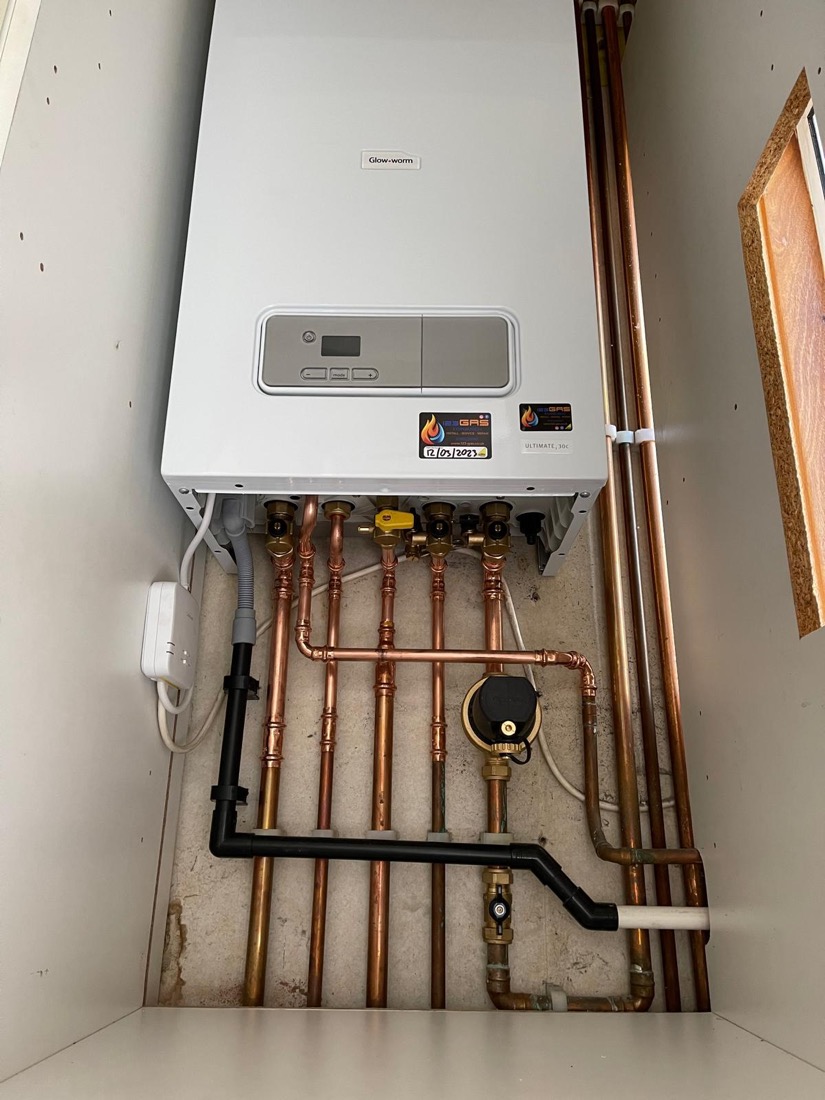 A serviced Glow-worm boiler with the 123-Gas record sticker and service date attached
