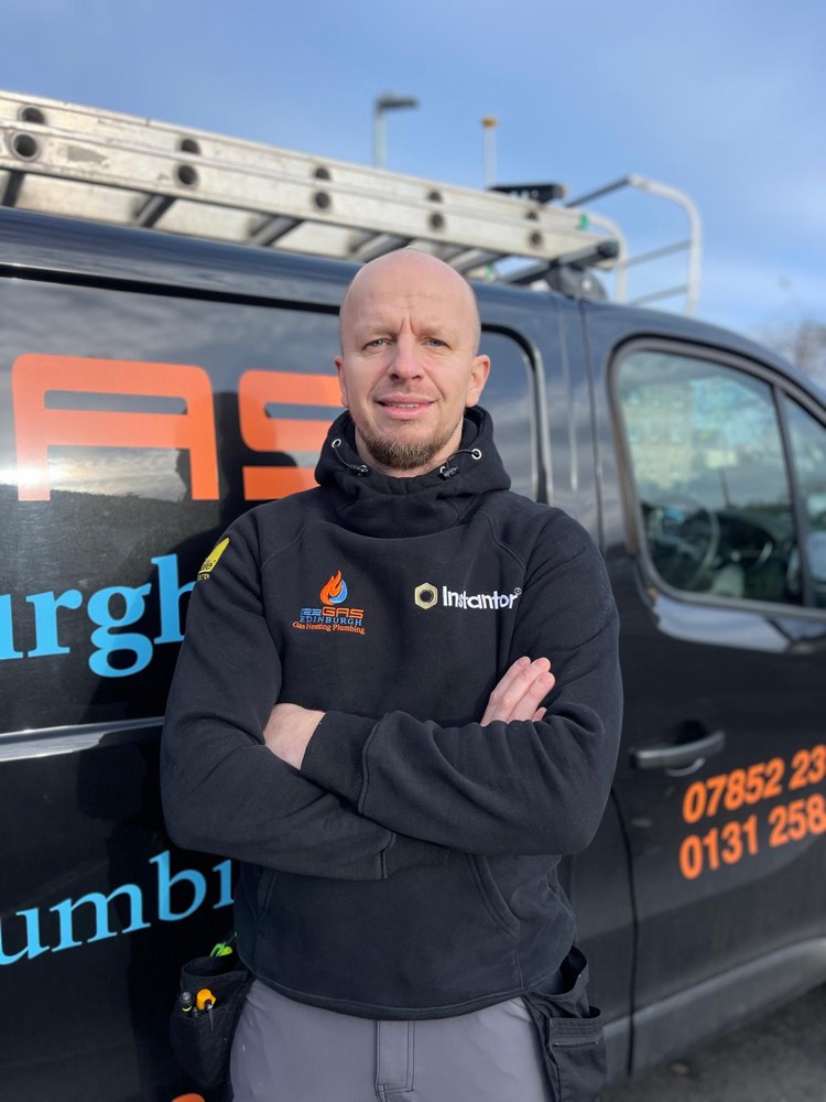 A 123-Gas Edinburgh heating engineer standing in front of the branded company van