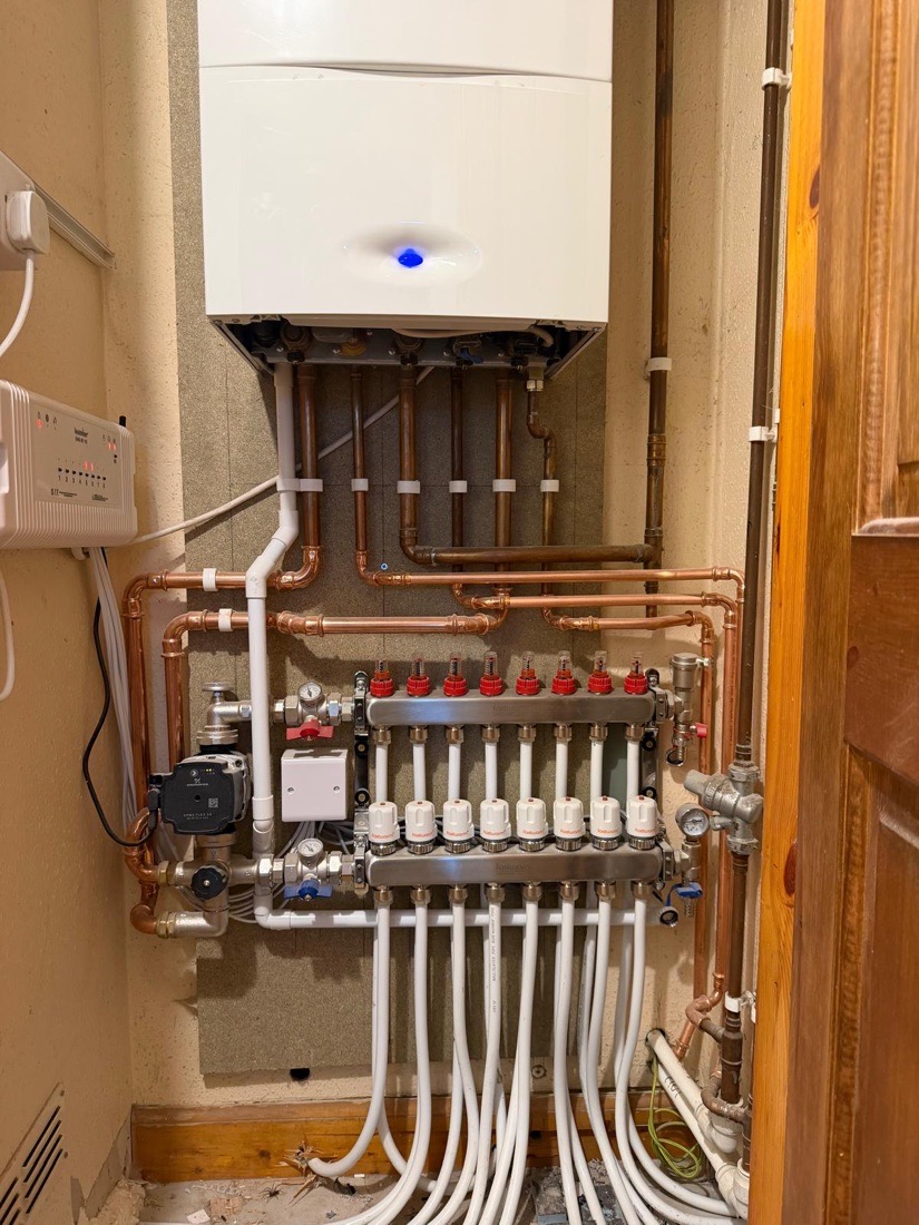 A boiler installed above an eight-zone underfloor heating manifold